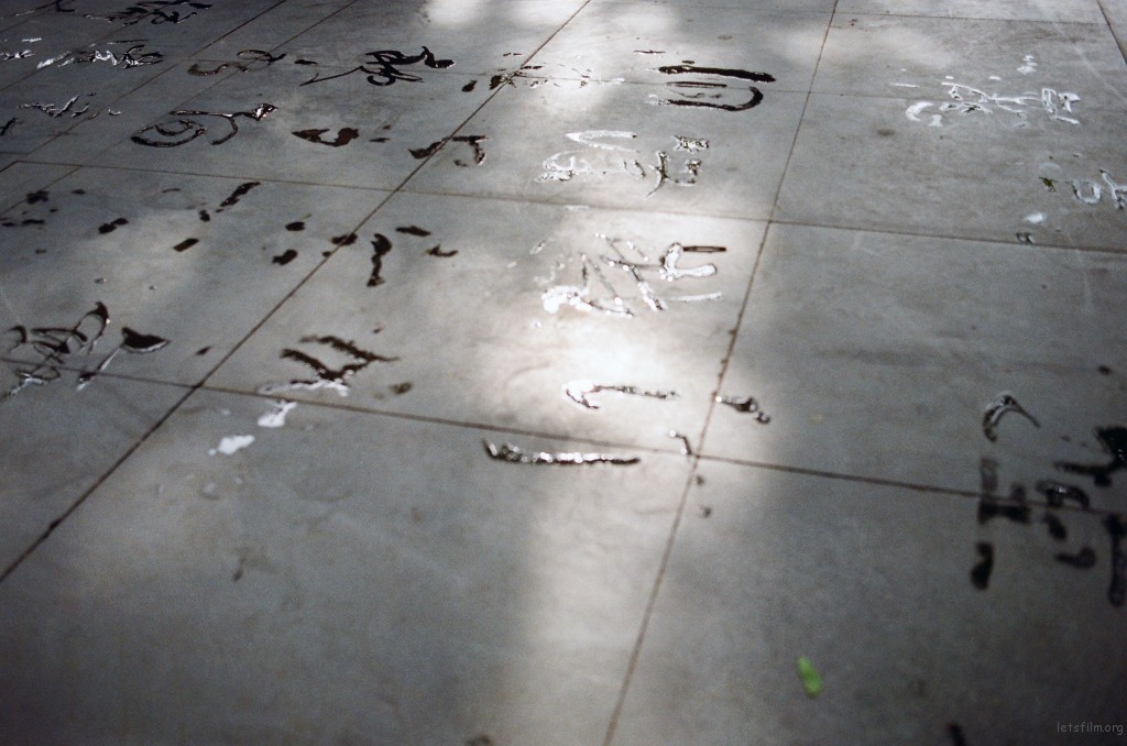 湖大老教授写的字。几个书法爱好老者几乎每天都会来练字。弯腰屈膝背挺直，斗大的毛笔直接在地上蘸水挥毫，很潇洒。